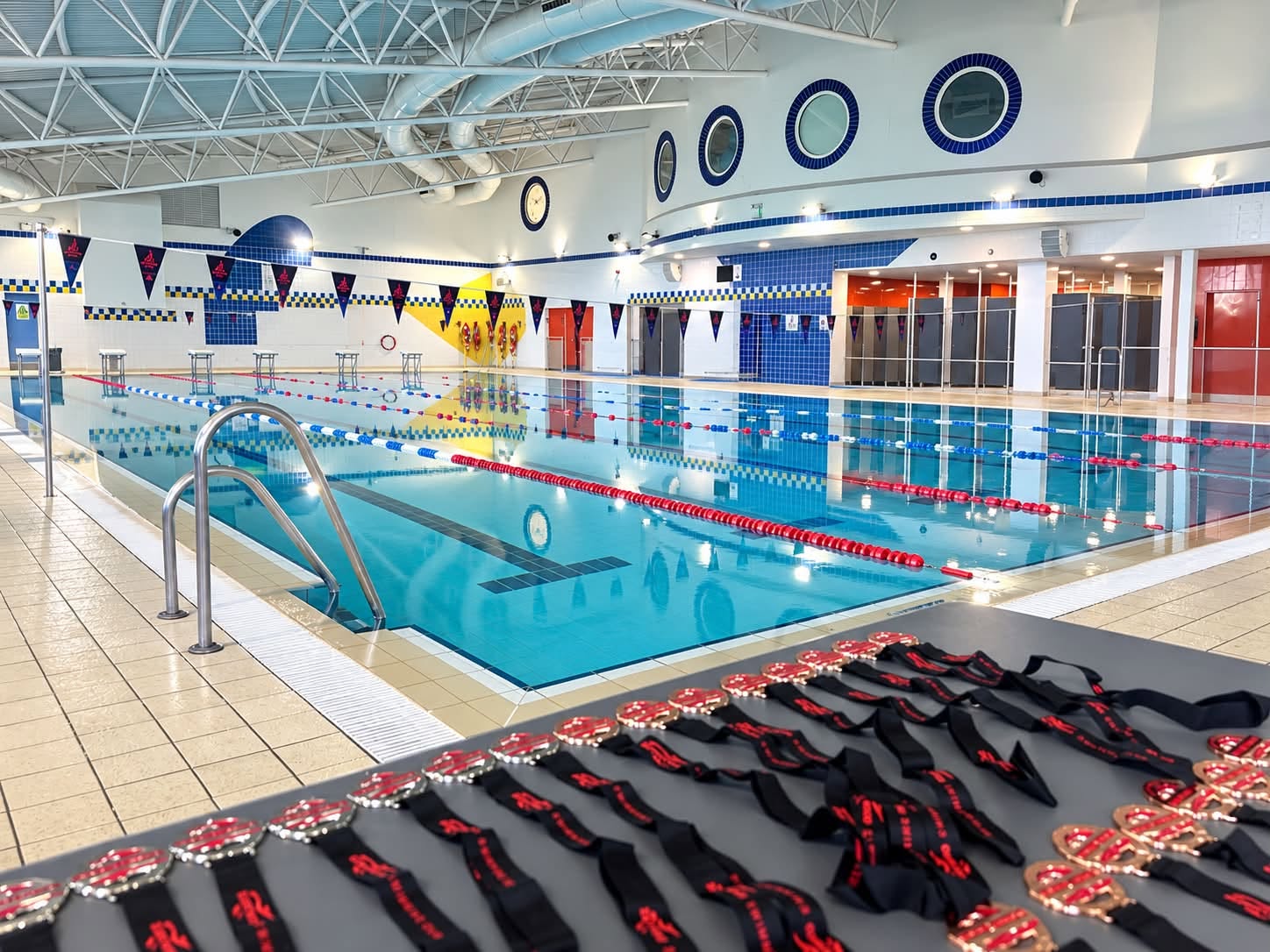 The club's training pool, with lane ropes in place and a table of medals ready for presentation.